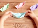 Enfant Détient Le Navire De L'origami Dans Ses Mains. Navires Colorés  Papier Origami Pliage Sur Une Table En Bois. Préscolaire Et Papier De  Maternelle à Pliage Papier Enfant