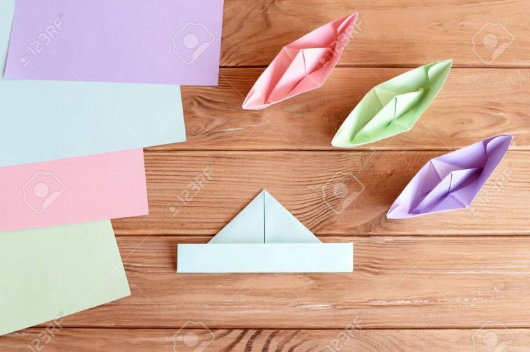 Ensemble De Bateaux Origami Et Feuilles Carrées De Papier Coloré Sur Une  Table En Bois. Comment Faire Un Simple Navire Origami. Tutoriel De Pliage serapportantà Pliage Papier Enfant