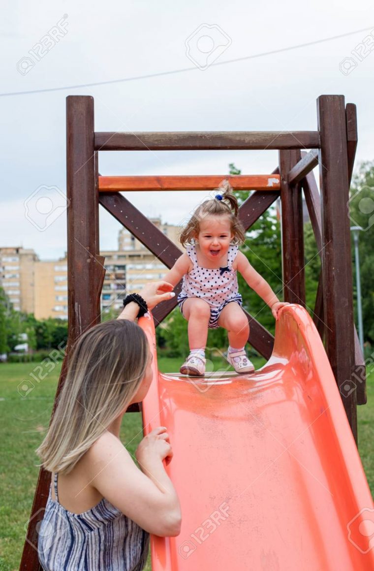 Heureuse Petite Fille Sur La Diapositive À L'aire De Jeux Pour Enfants à Jeux Pour Petite Fille