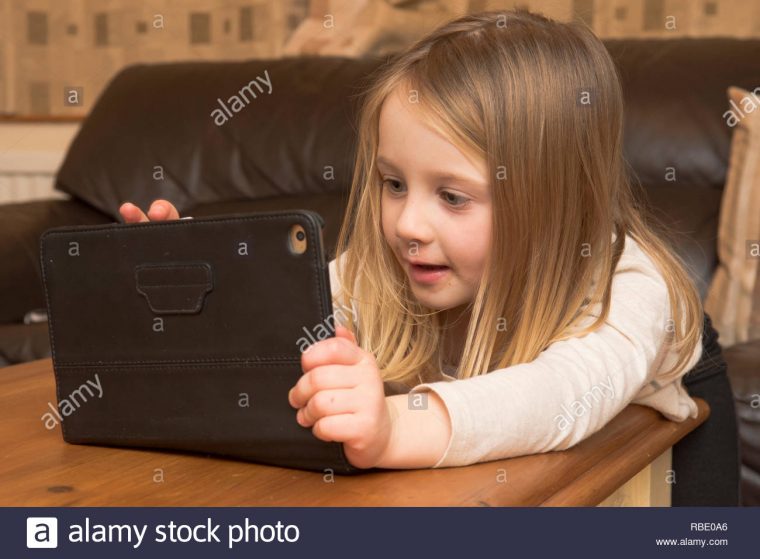 Jeune Fille Jouant Avec Un Appareil Numérique, Tablette intérieur Tablette Enfant Fille