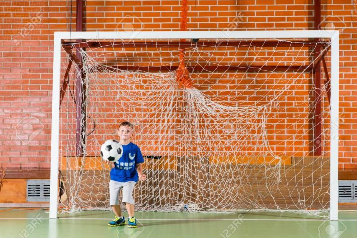 Jeune Garçon Jouant Gardien De But Pour Un Jeu De Soccer Intérieur En  Tenant Le Ballon Dans Sa Main Comme Il Regarde Les Joueurs à Jeux De Gardien De But