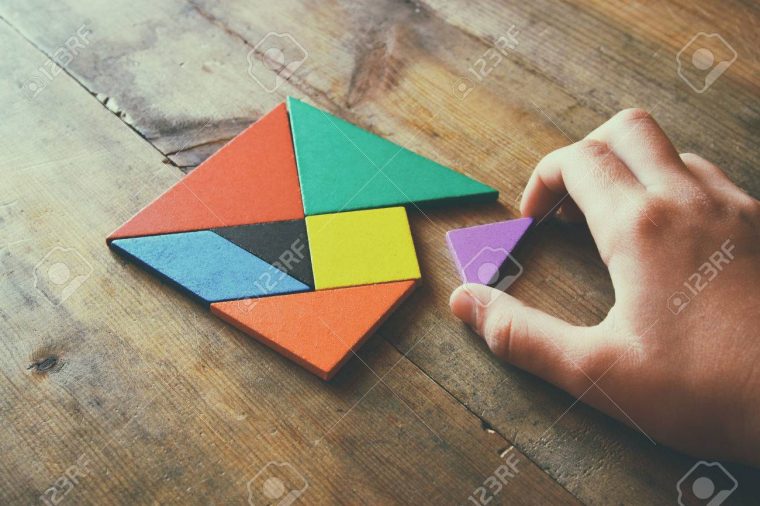 La Main D'enfant Tenant Une Pièce Manquante Dans Un Puzzle Carré De  Tangram, Sur La Table En Bois. à Tangram Enfant