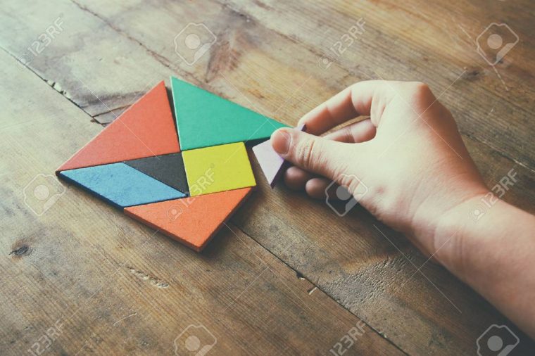 La Main D'enfant Tenant Une Pièce Manquante Dans Un Puzzle Carré De  Tangram, Sur La Table En Bois. intérieur Tangram Enfant