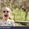 Petit Enfant Sourire Sur Swing En Cour D'été. Fashion Girl avec Jeux Pour Petit Enfant