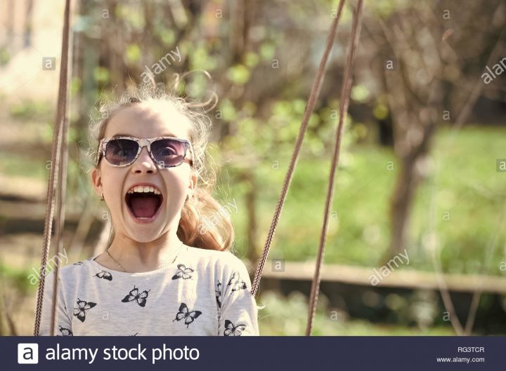 Petit Enfant Sourire Sur Swing En Cour D'été. Fashion Girl avec Jeux Pour Petit Enfant