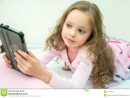 Petite Fille Heureuse Se Trouvant Sur Le Lit Avec La avec Tablette Enfant Fille
