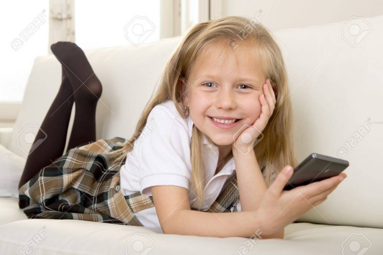 Sweet 6 Ou 7 Ans Blonde Petite Fille Mignonne Et Belle En Uniforme Scolaire  Couché Sur La Maison Canapé Canapé En Utilisant L'application Internet Sur concernant Jeux De Petite Fille De 6 Ans