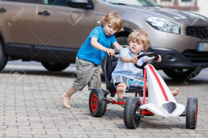 Deux Enfants Heureux Amuser Avec Voiture De Course De Jouets Dans Le Jardin  D'été, À L'extérieur. Frère Active Pousser La Voiture Avec Son Jeune dedans Plein De Jeux De Voiture