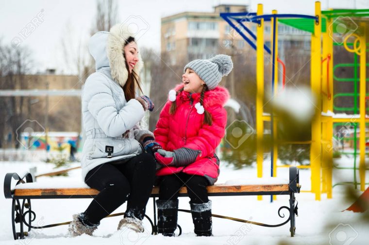 Deux Filles Heureuse, Mère Et Fille Assise Sur Un Banc Sur Une Aire De Jeux  Dans Le Parc De La Ville Au Jour D'hiver Glacial. encequiconcerne Jeux De Deux Fille