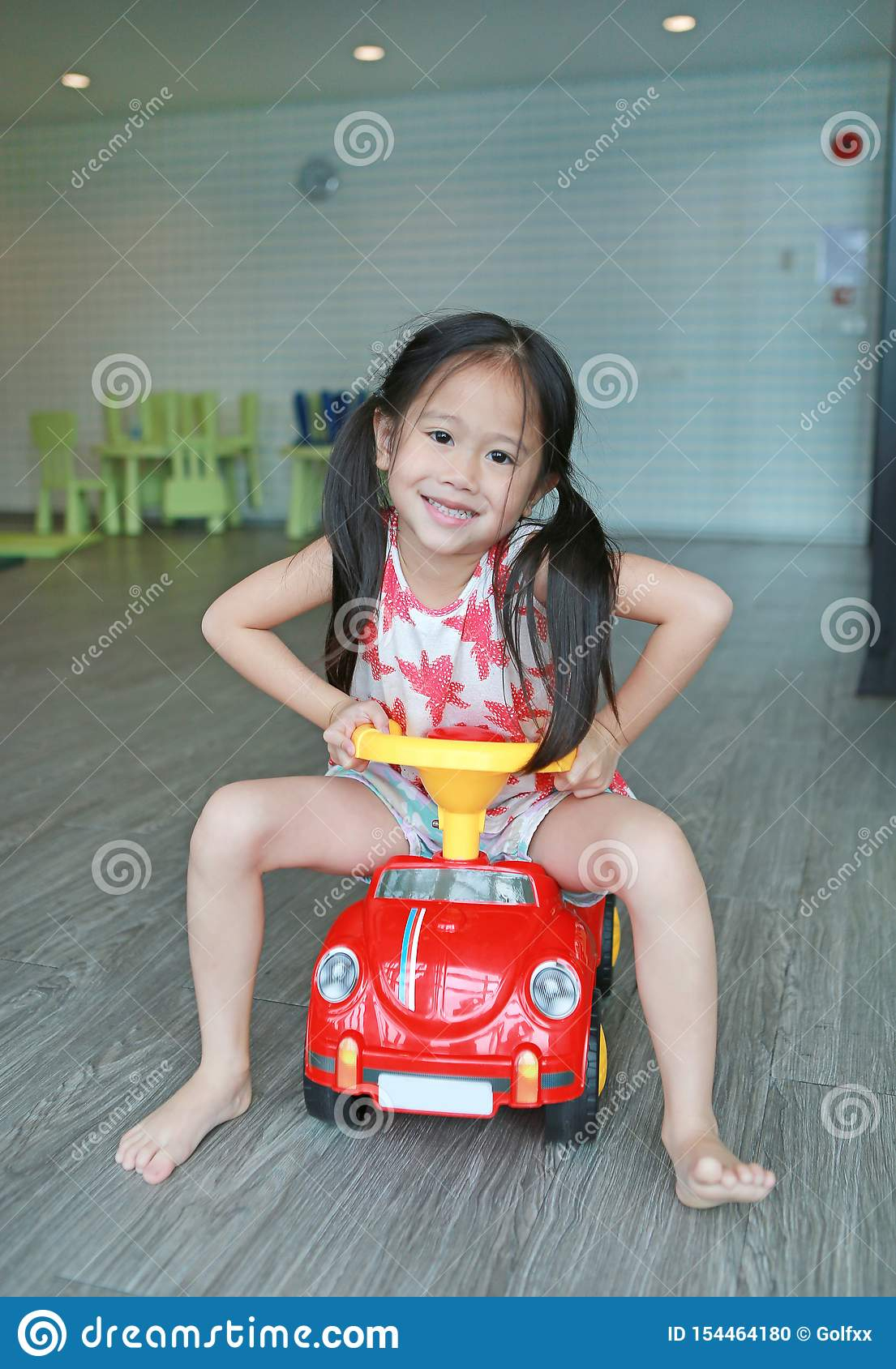 Fille Asiatique De Sourire Heureuse D'enfant Conduisant Le dedans Jeux De Fille De Voiture