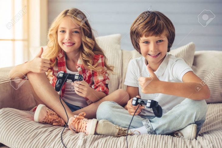 Jolie Petite Fille Et Garçon Jouent Console De Jeu, Montrant Les Pouces,  Regardant La Caméra Et Souriant Tout En Étant Assis Sur Le Canapé À La  Maison tout Tout Les Jeux De Fille Et De Garcon