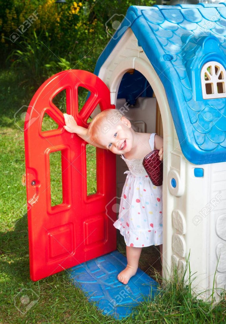 Petit Bébé Fille Portant Robe Blanche Regardant Plastique Maison De Jeu  Porte Dans Une Aire De Jeux D'été à Jeux Bebe Fille