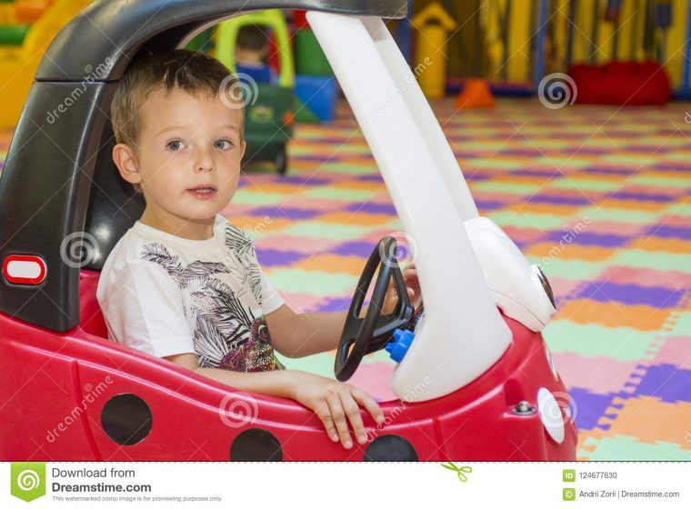 Petit Enfant Dans Une Voiture Rouge De Jouet Au Terrain De avec Jeux De Voiture Rouge