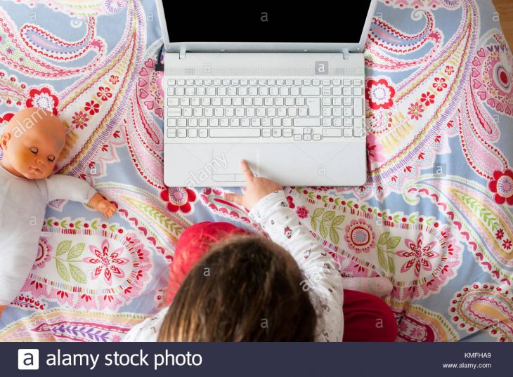 Petite Fille Assise Dans Le Lit Et Jouer À Des Jeux En Ligne concernant Jouer A Des Jeux De Fille