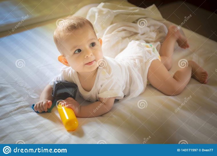 Peu Bébé 8 Mois De Mensonges Sur Un Lit Blanc Jeux destiné Jeux Bebe Fille