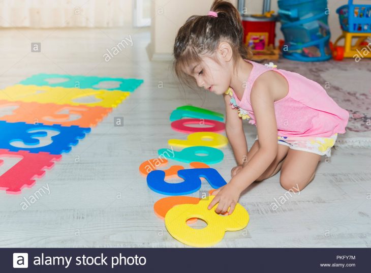 Vue Latérale D'une Mignonne Petite Fille Est Assise Et Tapis tout Jeux De Fille Puzzle